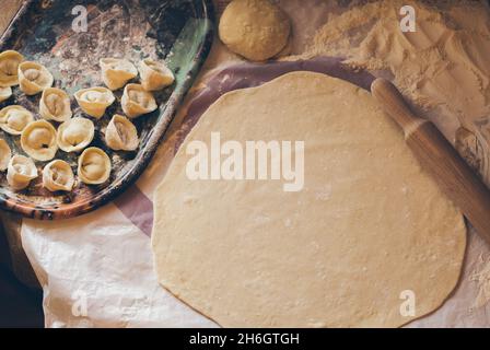 Knödel auf einem ovalen Tablett und gerollter Teig, Draufsicht Stockfoto