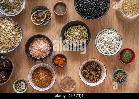 Set von Schüsseln mit Zutaten für Fusion Food Rezepte. Schwarze Bohnen, Sternanise, Reis, Chia und Kakao, Sternanise, Schwarzer Pfeffer, Panela Stockfoto