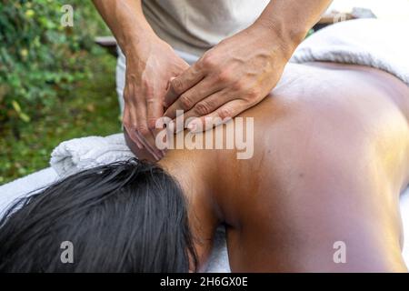 Die Hände des Mannes massieren den Hals einer multirassischen Frau Stockfoto