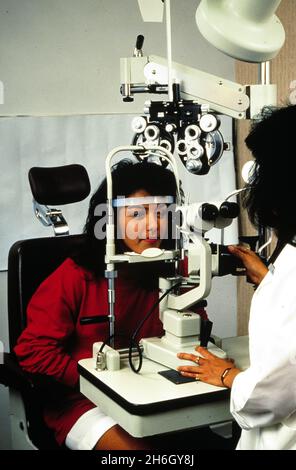 Austin Texas USA, um 1988: Hispanischer Teenager, der eine Augenuntersuchung in einem Augenarztbüro erhält. MR RR-026-29,32. ©Bob Daemmrich Stockfoto