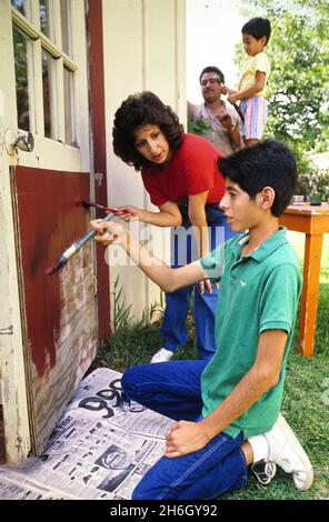 Austin Texas USA, 1988: Hispanische Familie, die an einem Schuppen in ihrem Hinterhof Wartung macht. MR RR-0101 ©Bob Daemmrich Stockfoto