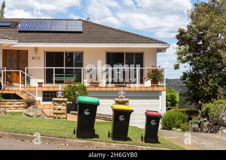 Sydney Haus in BILGOLA-HOCHEBENE, Wheelie-Behälter draußen für rat Entleerung und Sonnenkollektoren auf dem Dach platziert, NSW, Australien Stockfoto