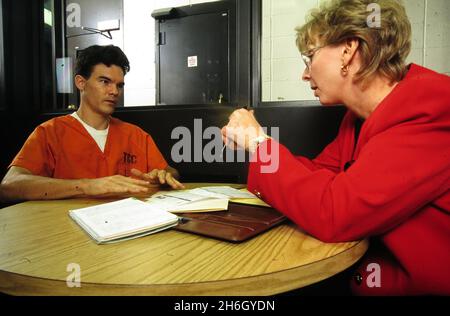 Austin Texas USA, 1997: Anwältin (rechts) und Gefangene sprechen im Travis County Gefängnis, das sich in der Gegend aufhielt, über seinen Fall. HERR EU-221-223 ©Bob Daemmrich Stockfoto