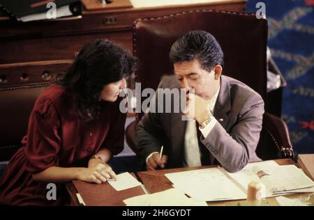 Austin Texas USA, 1991: Die spanischer Gesetzgeber von Texas, Lena Guerrero, links, und Gonzalo Barrientos, rechts, geben sich im Texas Capitol in der Kammer des Repräsentantenhauses. ©Bob Daemmrich Stockfoto