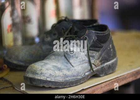 Alte Stiefel, schwarze Schuhe schmutzig auf dem Schuhträger, Militärstiefel Stockfoto