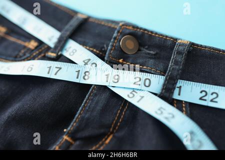 Denim-Hosen oder Jeans mit blauem Maßband um die Taille Stockfoto