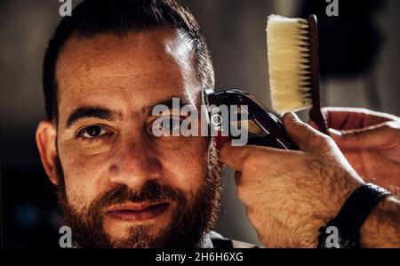 Nahaufnahme der Trimmermaschine. Prozess des Haarschneidens im Friseursalon. Stockfoto