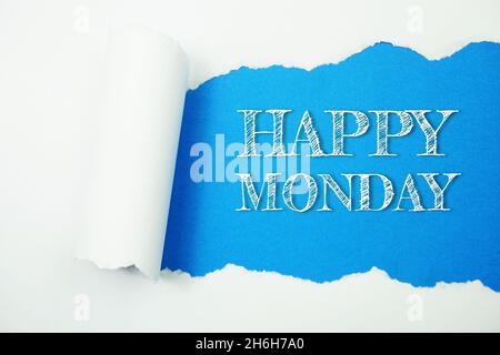 Happy Monday-Wort auf blauem Hintergrund mit zerrissenem Papier Stockfoto