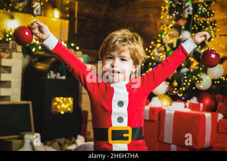 Weihnachten Kinderträume. Aufgeregt Kind Junge mit Spaß in der Nähe Weihnachtsbaum. Stockfoto