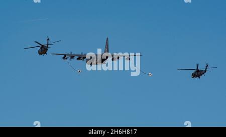 Ein HC-130J Combat King II und zwei HH-60W Pave Hawks, Teil der Desert Lightning Team (DLT) Combat Search and Rescue Demonstration, simulieren eine Luftbefüllung während der Thunder and Lightning Over Arizona Air Show und Open House 2021 auf der Davis-Monthan Air Force Base, Arizona, 6. November 2021. DM ist die Heimat der 563. Rettungsgruppe, die für die Rettung verantwortlich ist, mit einem HC-130J Combat King II Squadron, HH-60G Pave Hawk Squadron, Pararescue Squadrons, Wartungsgeschwadern und einem Operations Support Squadron. (USA Foto der Luftwaffe von Staff Sgt. Kristine Legate) Stockfoto