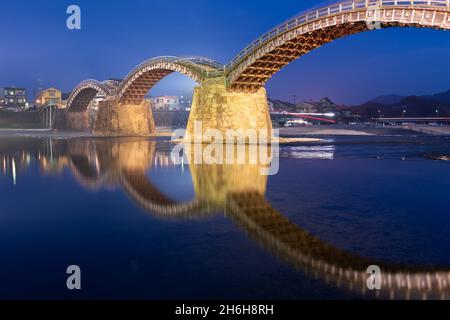 Iwakuni, Yamaguchi, Japan in der Kintaikyo Brücke über den Nishiki Fluss in der Dämmerung. Stockfoto