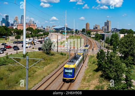 Ein Blick von der Martin Olav Sabo Brücke auf die Skyline von Minneapolis mit Light Rail und Autoverkehr im Vordergrund. Minneapolis Minnesota, USA Stockfoto