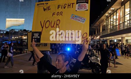 Ein israelischer Anti-vax-Protestler hält während einer Demonstration gegen die erzwungene Covid-Impfung und die Green-Pass-Regeln am 13. November 2021 in Tel Aviv, Israel, ein Schild mit der Aufschrift „Wir kämpfen für Ihre Freiheit“ hoch. Ein Gremium von medizinischen Experten des israelischen Gesundheitsministeriums hat kürzlich in einer geheimen Abstimmung für einen COVID-Impfstoff für Kinder gestimmt. Stockfoto