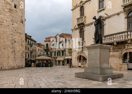 Split, Kroatien - 12. November 2021: Der Obstplatz im historischen Stadtzentrum von Split mit der Statue von Marko Marulic im Vordergrund Stockfoto