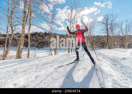 Man Cross Country Skate Skiing Style - Nordic Ski im Wald. Mann im Winter macht Spaß Ausdauer Wintersport im Schnee auf Langlaufski Stockfoto