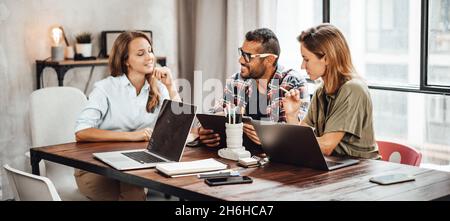 Gruppe von jungen Menschen, die zusammen arbeiten oder studieren. Hipster-Team im Coworking. Junge, moderne Geschäftskollegen. Teamarbeit. Startup-Konzept Stockfoto