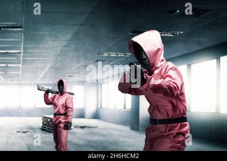 Krimineller Mann in rosa Uniform und einer versteckten Maske mit der Schrotflinte nach dem Raub des Gebäudes Stockfoto