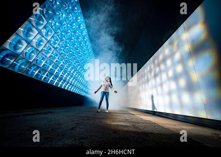 Elysha Joseph, Jurastudentin an der Plymouth University, geht durch die Kunstinstallation Sola des Künstlerkollektivs Squidsuup bei Illuminate, dem jährlichen Lichtkunstevent im Royal William Yard in Plymouth, wo die Veranstaltung wieder eintauchen wird, um immersive digitale Installationen zu präsentieren. Bilddatum: Montag, 15. November 2021. Stockfoto