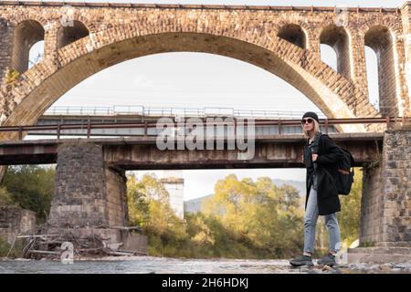 Alte gewölbte Steinbrücke, Reise Mädchen Tourist in der Nähe des Flusses, Hintergrund der Brücke mit der Eisenbahn, Stadtbrücke. Stockfoto