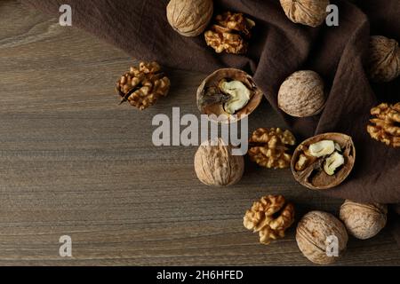 Walnüsse mit Küchentuch auf Holzhintergrund Stockfoto