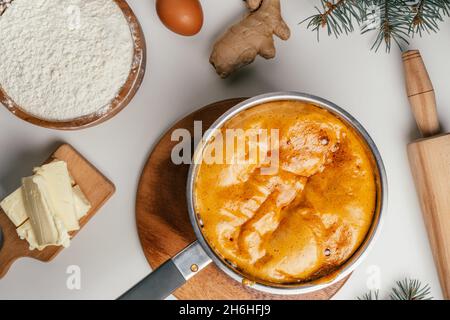 Schritt-für-Schritt-Anleitung zum Backen von Weihnachts-Lebkuchen. Schritt 5: Rühren Sie um, bis die Sodareaktion vollständig verschwunden ist. Draufsicht Stockfoto