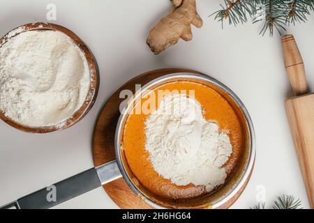 Schritt-für-Schritt-Anleitung zum Backen von Weihnachts-Lebkuchen. Schritt 8: Mehl nach und nach dazugeben. Draufsicht Stockfoto