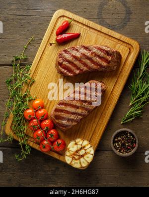 Saftig und zart zwei ketogene Spitzenblattsteaks auf Holzbrett mit Kräutern und Gewürzen Stockfoto