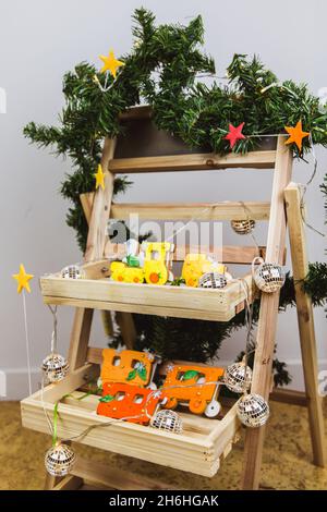 Handbemalter Weihnachts Lebkuchen orange Zug auf Holzständer. Weihnachtsbaum mit Lichtern geschmückt. Nahaufnahme. Stockfoto