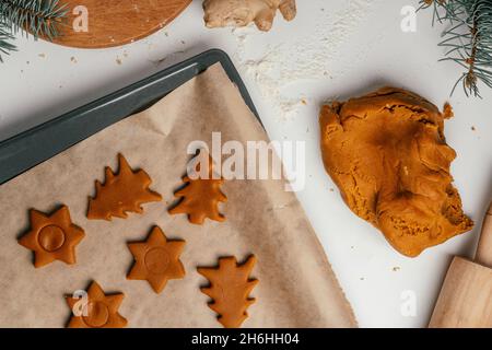 Schritt-für-Schritt-Anleitung zum Backen von Weihnachts-Lebkuchen. Schritt 12: Cookies mit Ausstechformen ausschneiden und auf Backpapier legen. Draufsicht Stockfoto