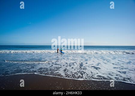 Eine ältere Studentin, die am North Sands in Scarborough beim Surfen unterrichtet wird Stockfoto