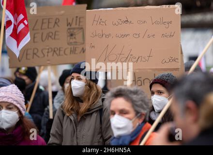 München, Deutschland. November 2021. Vor dem Krankenhaus in Großhadern nehmen Gesundheitshelfer an einem Warnstreik Teil und halten ein Plakat mit der Aufschrift „erst auf dem Balkon klatschen – dann ins Gesicht klatschen“ hoch. In der aktuellen Tarifverhandlungsrunde fordert Verdi fünf Prozent mehr Lohn, aber mindestens 150 Euro pro Monat. Im Gesundheitswesen werden monatlich 300 Euro mehr gefordert. Quelle: Sven Hoppe/dpa/Alamy Live News Stockfoto