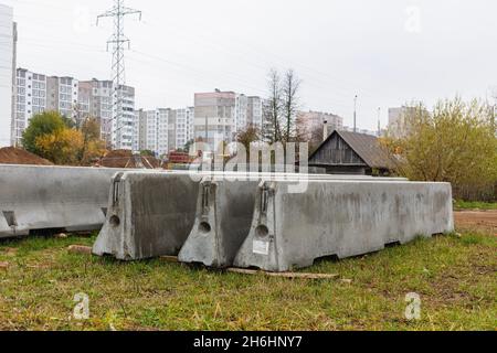 Betonstoßstangen auf einer Baustelle. Hackmaschinen für die Verkehrssicherheit. Stockfoto