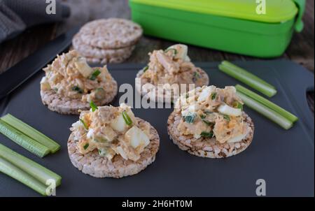 Bereiten Sie eine Mahlzeit für Fitness oder Bodybuilding mit einem proteinreichen und fettarmen Thunfisch-Salat mit braunen Reiscrackern und frischen Sellerie-Sticks vor Stockfoto