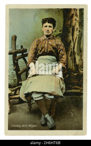 Original Edwardian getönte Porträtpostkarte von Colliery Girl, Wigan (Lancashire, England, UK) in Hosen und Schürze, um 1905. Stockfoto