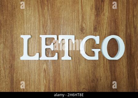 Let Go Wort Alphabet Buchstaben auf Holzhintergrund Stockfoto