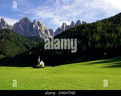 Atemberaubende Aussicht auf die berühmte St. Johan Kirche und die Geisler Berge im Hintergrund. Santa Maddalena, Südtirol, Italien Stockfoto