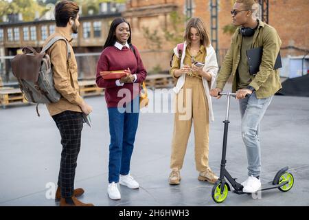 Multirassische Studenten stehen und reden tagsüber im Freien Stockfoto