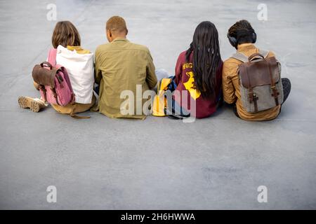 Rückansicht der Studenten sitzen und ruhen auf Asphalt Stockfoto