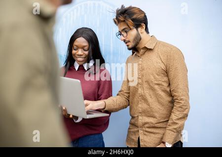 Zwei multirassische Studenten beobachten einige auf dem Laptop Stockfoto