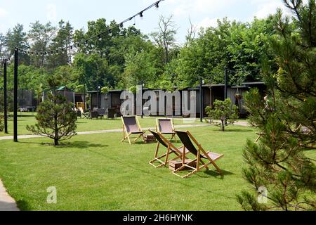 Pavillon mit hölzernen Nischen im ländlichen Golfclub der Vororte. Der Platz für Freizeit Longe, Liegestühle. Arten auf dem Spielplatz Bouncing und Springen auf dem t Stockfoto