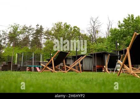 Pavillon mit hölzernen Nischen im ländlichen Golfclub der Vororte. Der Platz für Freizeit Longe, Liegestühle. Arten auf dem Spielplatz Bouncing und Springen auf dem t Stockfoto