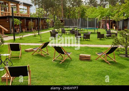 Pavillon mit hölzernen Nischen im ländlichen Golfclub der Vororte. Der Platz für Freizeit Longe, Liegestühle. Arten auf dem Spielplatz Bouncing und Springen auf dem t Stockfoto