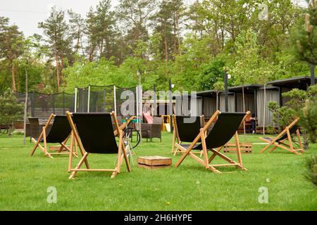 Pavillon mit hölzernen Nischen im ländlichen Golfclub der Vororte. Der Platz für Freizeit Longe, Liegestühle. Arten auf dem Spielplatz Bouncing und Springen auf dem t Stockfoto