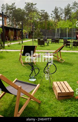 Verschiedene Wasserpfeifen in der Natur an einem warmen sonnigen Tag. Östlicher Shisha Rauchen, aktive Erholung an der frischen Luft. Liegestühle auf geen Gras. Der richtige Ort für le Stockfoto
