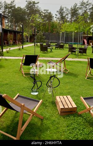 Verschiedene Wasserpfeifen in der Natur an einem warmen sonnigen Tag. Östlicher Shisha Rauchen, aktive Erholung an der frischen Luft. Liegestühle auf geen Gras. Der richtige Ort für le Stockfoto