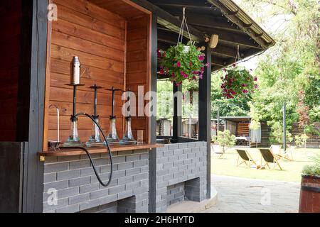 Verschiedene Wasserpfeifen in der Natur an einem warmen sonnigen Tag. Östlicher Shisha Rauchen, aktive Erholung an der frischen Luft. Liegestühle auf geen Gras. Der richtige Ort für le Stockfoto