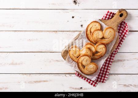 Palmier Blätterteig in Teller auf weißem Holztisch Stockfoto
