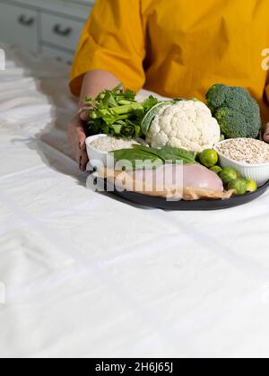 Elimination Diät-Konzept. Eine Frau vermeidet Lebensmittelallergene - Fisch, Meeresfrüchte, Milchprodukte, Erdnüsse, Nüsse, Eier, Schokolade, Weizen, Soja, Zitrusfrüchte. Stockfoto