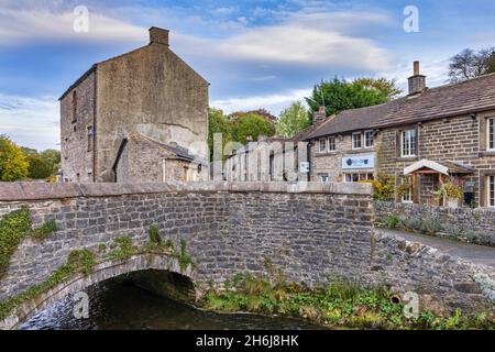 Brücke über Peakshole Water, ein Bach, der durch das malerische Dorf Castleton fließt, um den Fluss Noe im Peak District zu verbinden. Derbyshire. Stockfoto