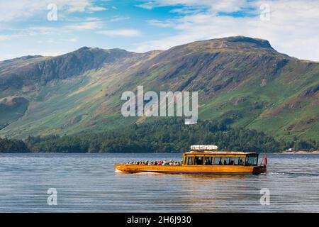 Lake District tourism, summer morning view of a ferry boat cruising Derwent Water with a view of the high Derwent Fells in the distance, England UK Stockfoto